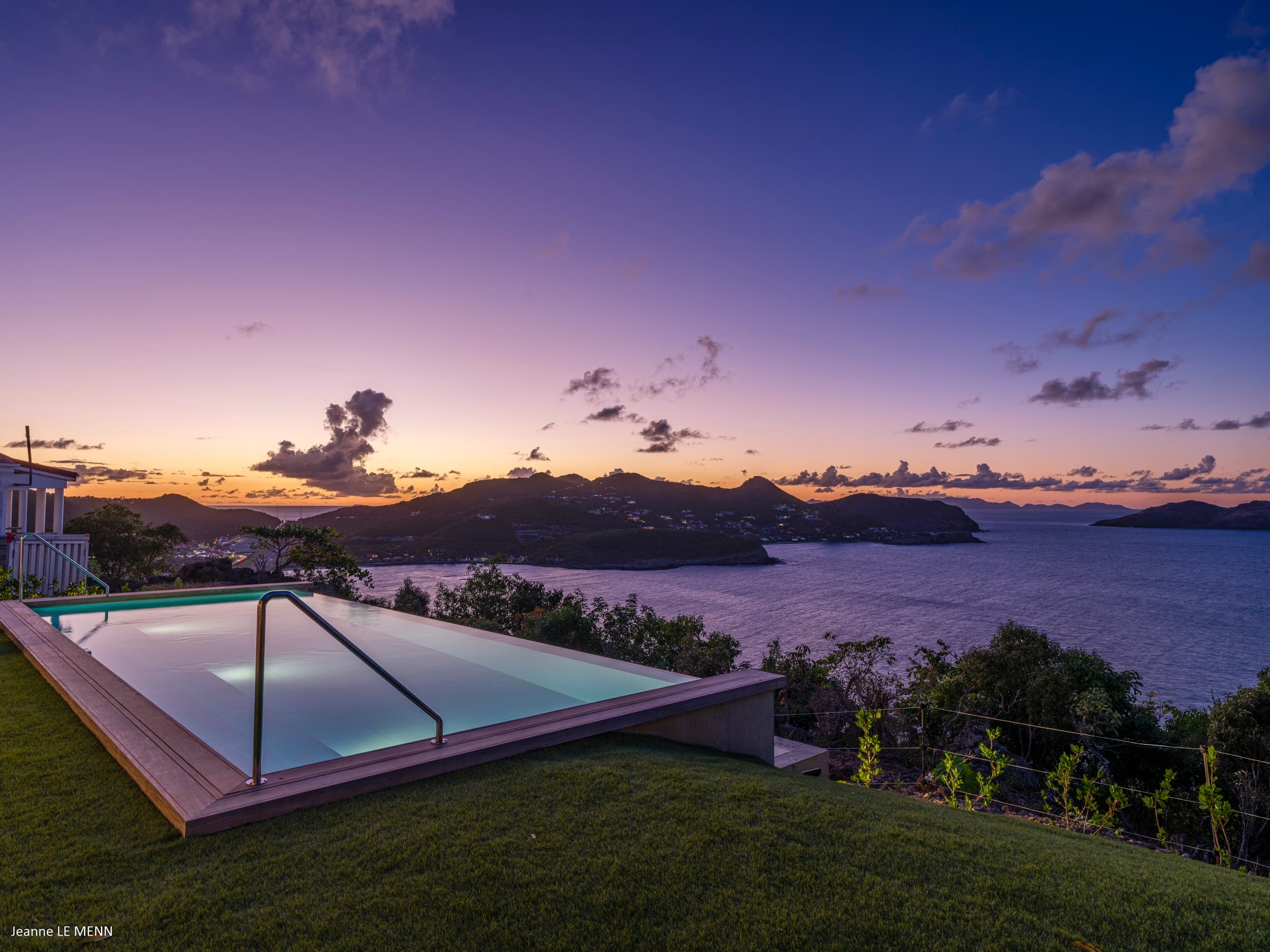 Infinity pool overlooking the ocean and airport at sunset
